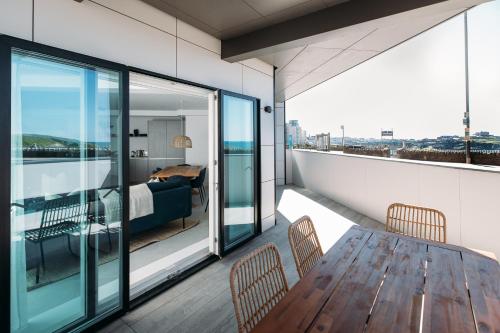 a balcony with a wooden table and chairs at Luxury Family Apartment with sea views in Newquay