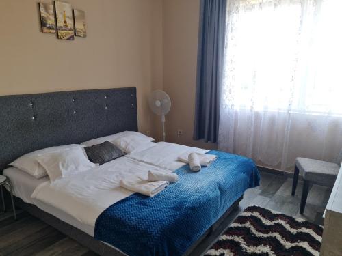 a bedroom with a bed with towels on it at Napfény Szállás in Szeged