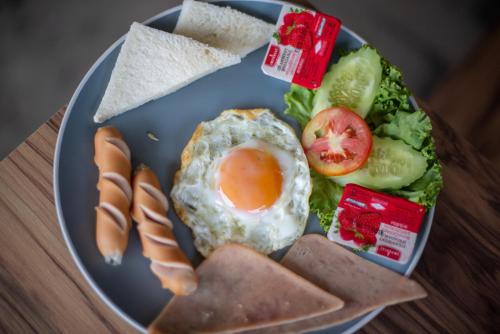 a blue plate of food with an egg and bread at Tarnsiri Boutique Resort in Kanchanaburi