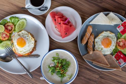 a table with plates of breakfast food on it at Tarnsiri Boutique Resort in Kanchanaburi