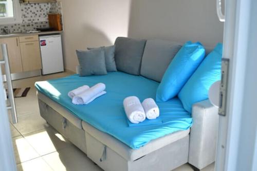 eine blaue Couch mit Kissen darauf in der Küche in der Unterkunft Havana Villas in Leptokaryá