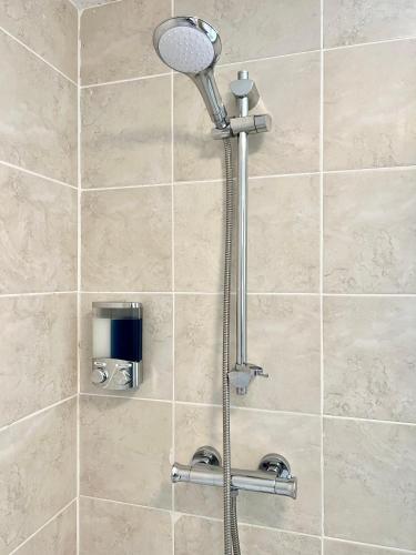 a shower with a shower head in a bathroom at New Forest Hideaway- Self Catering Accommodation in Newbridge