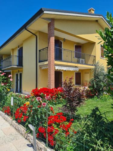 een huis met rode bloemen ervoor bij Casa Andrè in Pescantina