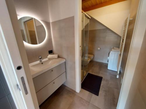 a bathroom with a sink and a mirror at Our Happy Place - casa vacanze per il viaggiatore Slow in Mandello del Lario