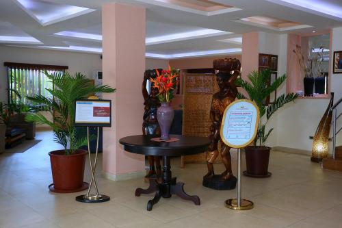 a lobby with a statue of a woman on a table at The Cape Hotel in Monrovia