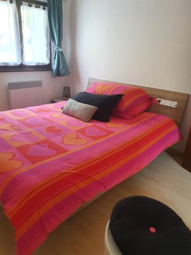 a bed with a colorful comforter in a bedroom at Appartement Fully in Fully