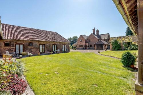 a large yard in front of two brick buildings at Holly Lodge Country Guest House in Blidworth