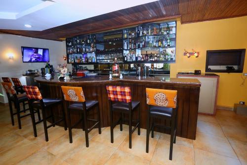 a bar in a restaurant with chairs around it at The Cape Hotel in Monrovia
