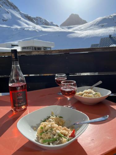 a table with a bowl of food and two glasses of wine at Génépis - Studio rénové Tignes Val Claret 4 pax in Tignes