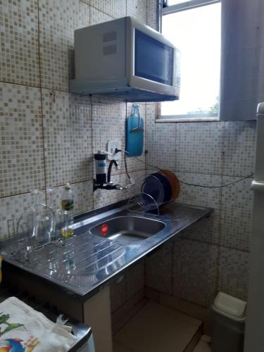 a kitchen counter with a sink and a microwave at Kitnet Aconchegante Em Benfica in Rio de Janeiro