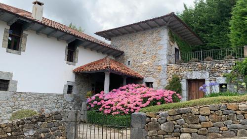 a house with pink flowers in front of it at El Jardin de las Magnolias Hotel in Quintana de Soba