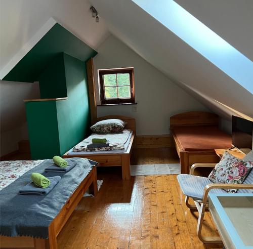 a attic room with two beds and a window at Osada Pienińska in Krościenko