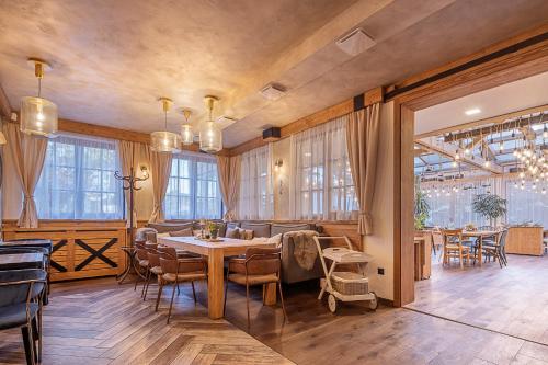 a dining room with a table and chairs and windows at Hotel McLimon in Nový Jičín