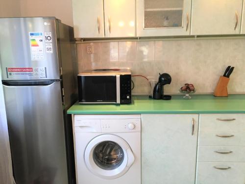 a kitchen with a microwave and a washing machine at Стаи за гости Димитрови in Burgas City