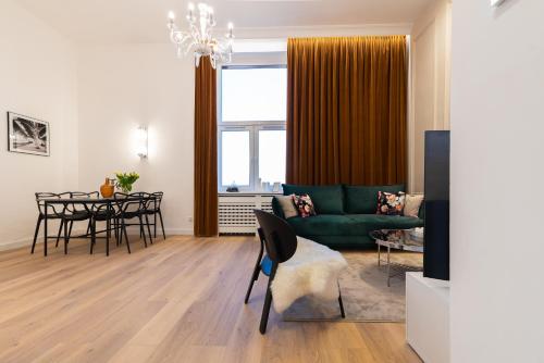ein Wohnzimmer mit einem grünen Sofa und einem Tisch in der Unterkunft A.S. Home Apartament Podwale in Breslau
