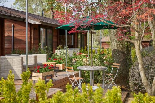 a patio with a table and chairs and an umbrella at Resol no Mori in Nagara