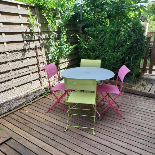 a table and four chairs on a wooden deck at Idéalement situé, spacieux et agréable, parking gratuit et classé 3 étoiles in Mende