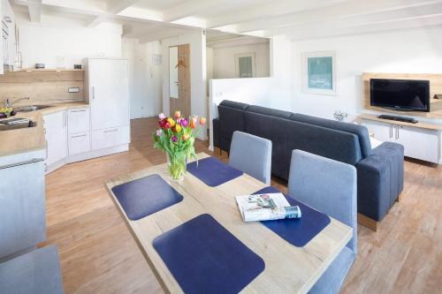 sala de estar con sofá y mesa con flores en Haus 3 Jahreszeiten Wg 16 en Norderney