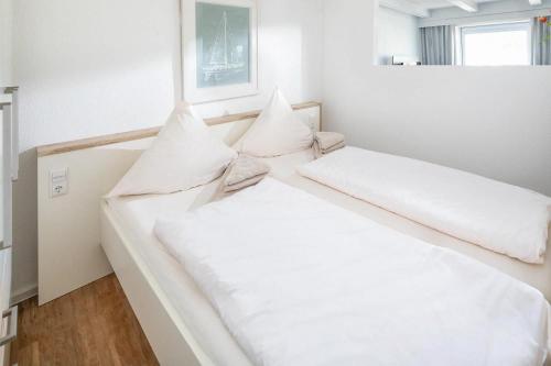 2 camas en una habitación con sábanas y almohadas blancas en Haus 3 Jahreszeiten Wg 16 en Norderney