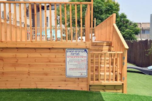a wooden fence with a gate and a sign at Domos Tiberias דומוס טבריה in Tiberias