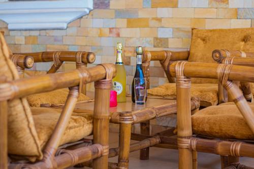 una mesa con 2 botellas de vino y 2 sillas en Ruk's Hotel, en Tamale