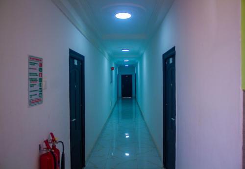 a hallway with blue walls and a hallway with two doors at Ruk's Hotel in Tamale