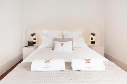 a white bed with two white towels on it at Casa Noronha Lima - Historic Stay in Alvarenga