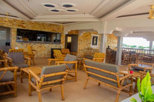 a restaurant with chairs and tables and a brick wall at Ruk's Hotel in Tamale
