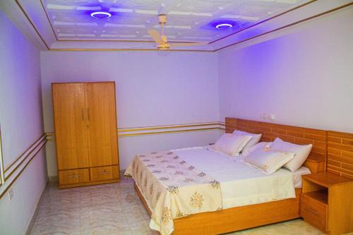 a bedroom with a bed with purple walls at Ruk's Hotel in Tamale