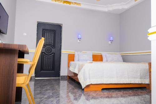 1 dormitorio con cama y puerta negra en Ruk's Hotel, en Tamale