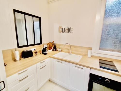 a white kitchen with a sink and a window at 2 pièces totalement rénové au cœur de Bourges in Bourges