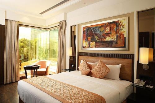 a bedroom with a large bed and a large window at Inde Hotel Signature Tower in Gurgaon