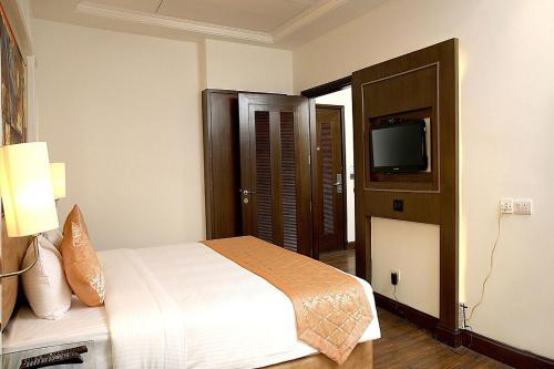 a hotel room with a bed and a television at Inde Hotel Signature Tower in Gurgaon
