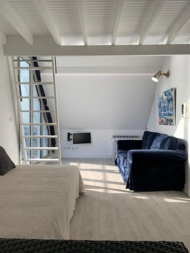 um quarto com uma cama, uma escada e um sofá em Blue bay studio terrasse em Deauville