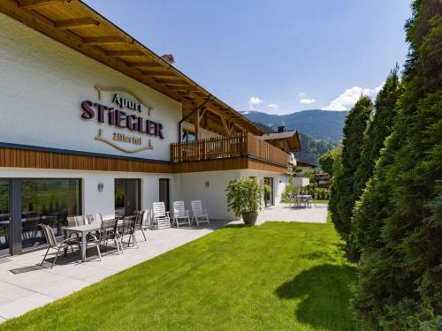 a building with a patio with a table and chairs at Apart Stiegler in Stumm