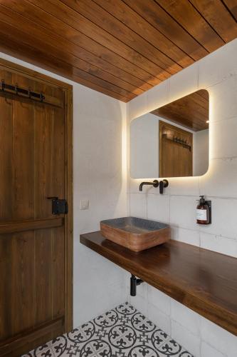 a bathroom with a wooden sink and a mirror at Agramada in Arnaia