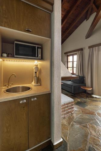 a kitchen with a sink and a living room at Agramada in Arnaia