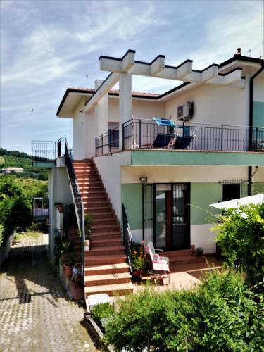 a white house with stairs and a balcony at Vivi Conero in Ancona