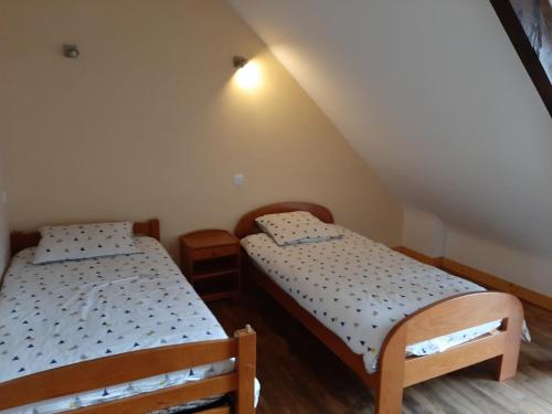 two twin beds in a room with a attic at LES GÎTES CELTIQUES DU PÈRE NICOLAS in Plumeliau Bieuzy