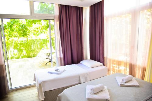 a hotel room with two beds and a large window at Balim Sultany in Çeşme