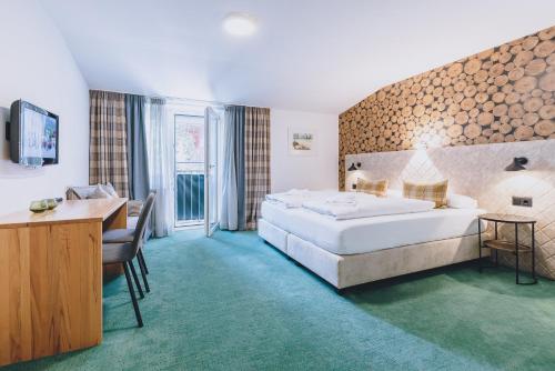 pokój hotelowy z dużym łóżkiem i biurkiem w obiekcie Alpine City Living by we rent, SUMMERCARD INCLUDED w mieście Zell am See