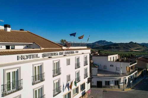 un hôtel avec deux drapeaux au-dessus d'un bâtiment dans l'établissement Hotel Sierra de Huesa, à Huesa