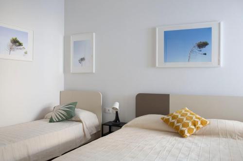 1 dormitorio con 2 camas y 2 cuadros en la pared en Le case di Vada/ Appartamento Pietra Bianca, en Vada
