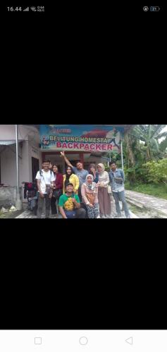a group of people standing in front of a sign at Belitung Backpacker in Tanjungpandan