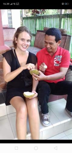 a man and a woman sitting on a bench at Belitung Backpacker in Tanjungpandan