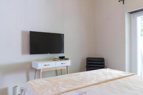 - une chambre avec un lit et une télévision murale dans l'établissement Tesoro Nascosto B&B, à Salerne