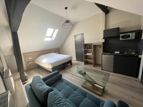 salon z niebieską kanapą i łóżkiem w obiekcie L'Escale du Vexin w mieście Chaumont-en-Vexin