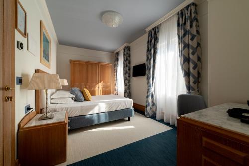 a bedroom with a bed and a desk with a lamp at Casa Bianca Al Mare in Lido di Jesolo