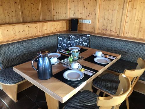 a wooden table with plates and a kettle on it at Pension und Café "Alte Straßenmeisterei" in Hasselfelde