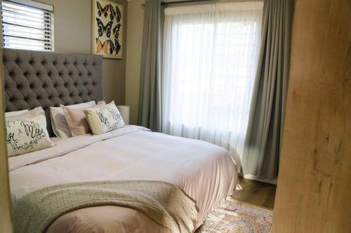 庫里南的住宿－Serene Luxury retreat in Cullinan，一间卧室设有一张大床和一个窗户。